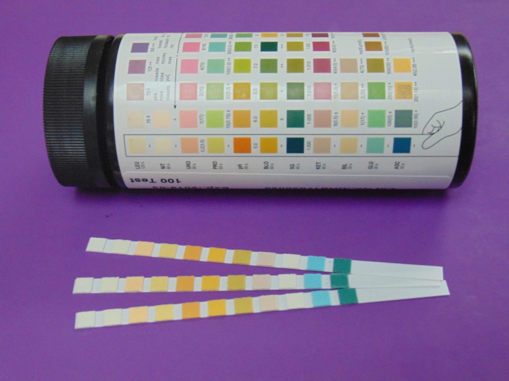 A jar of urine test strips that include glucose and ketone indicators