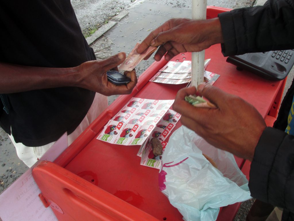 Street vendor selling scratch or “flex” cards, Goroka, 2015