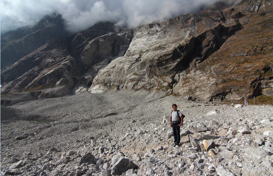 Figure 15. Dindu, the man who I was speaking with about the proposed hydropower project at the time of the earthquake, stands in the blast zone of the Langtang avalanche (Austin Lord).