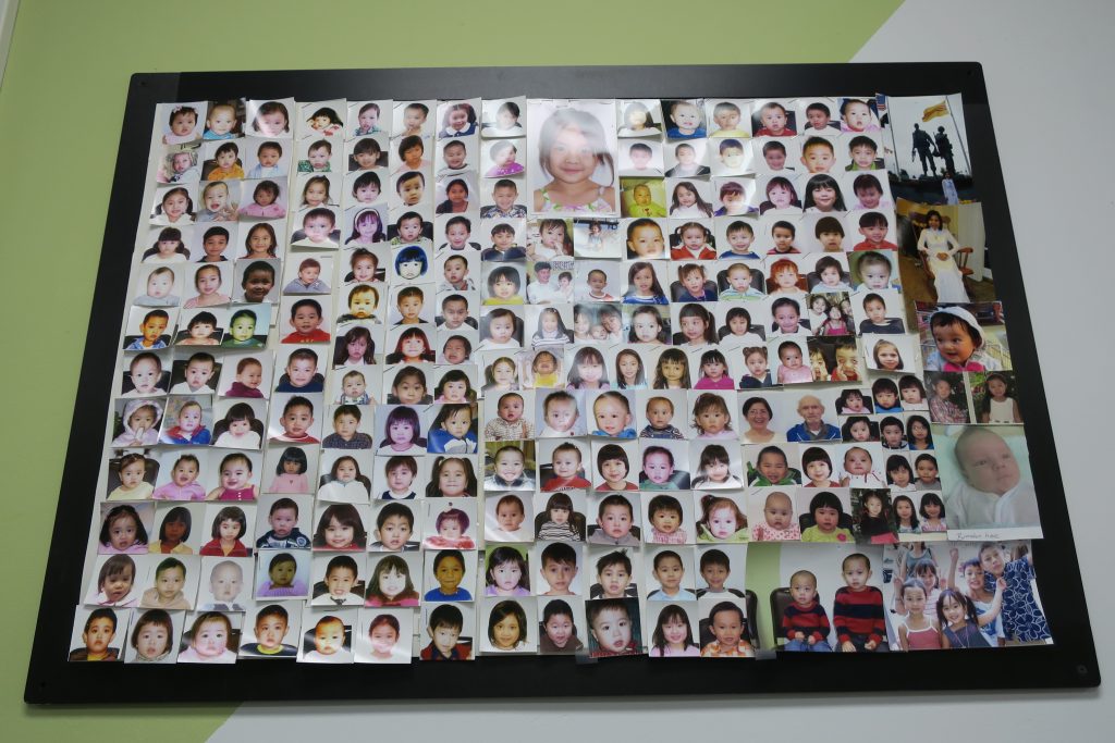 “Wall of customers” passport photos, Vietnamese American remittance shop. 